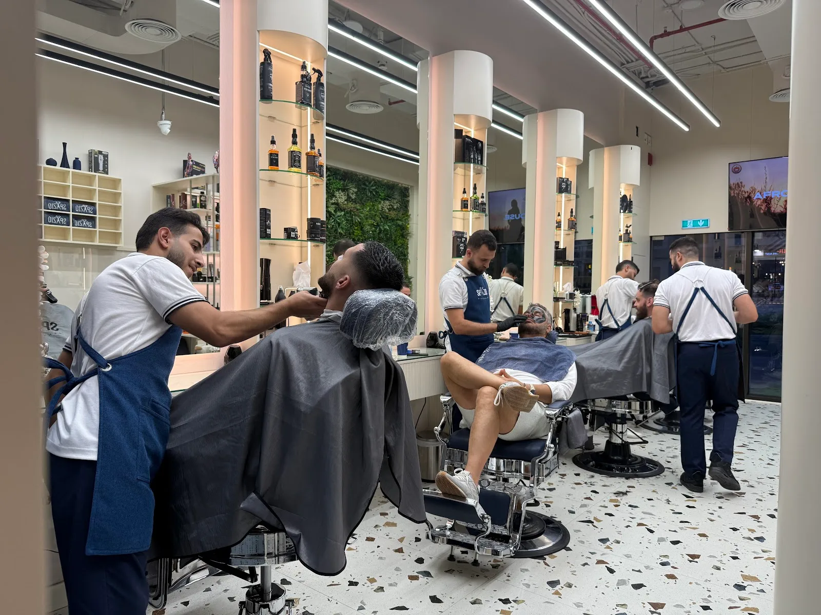 All three barbers working with every chair full at Spazio Gents Salon in JVC, Dubai