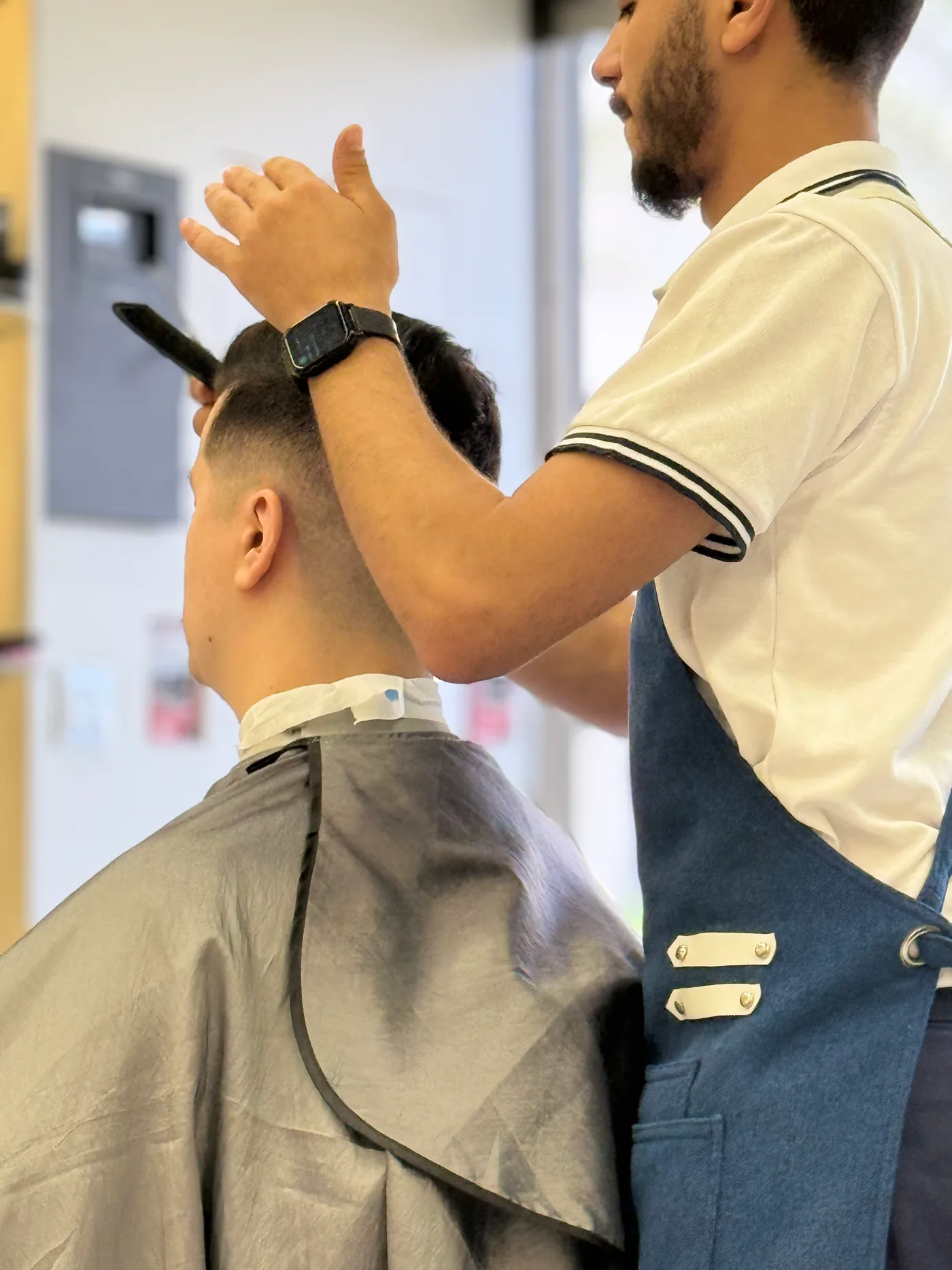 Barber styling a client’s hair after the cut at Spazio Gents Salon in JVC, Dubai