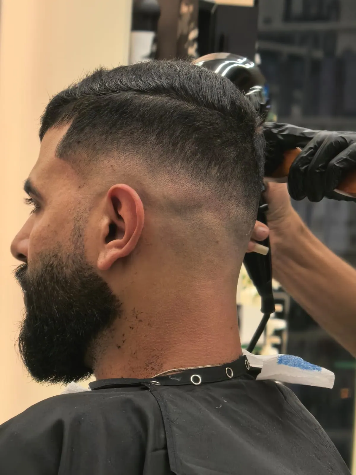 Close-up of beard shaping with clippers at Spazio barber shop in JVC