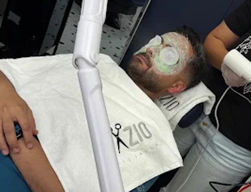 Client having a mens facial with a mask and eye pads at Spazio Gents Salon in JVC, Dubai