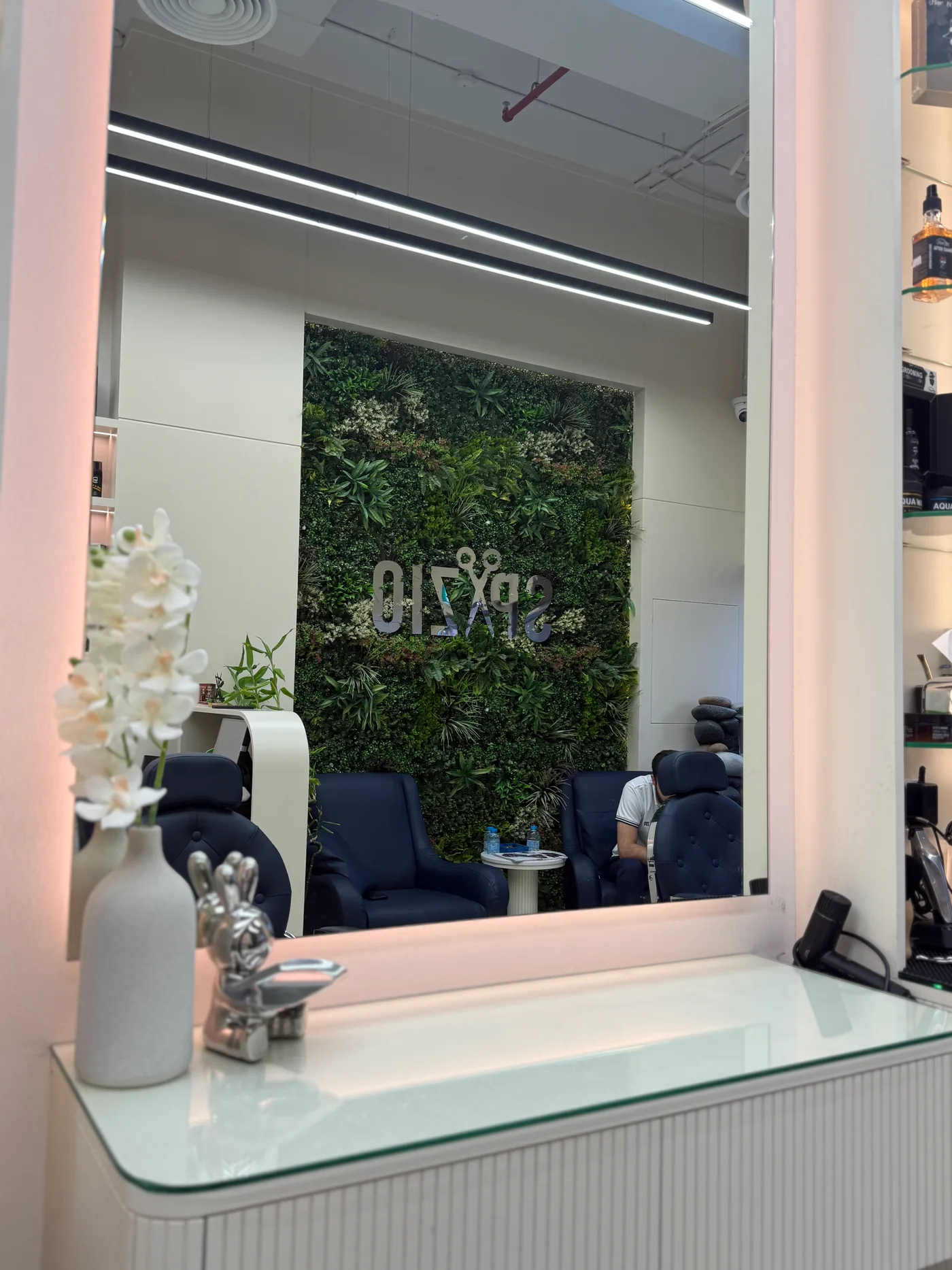 Mirror and green living wall inside Spazio Gents Salon in Jumeirah Village Circle