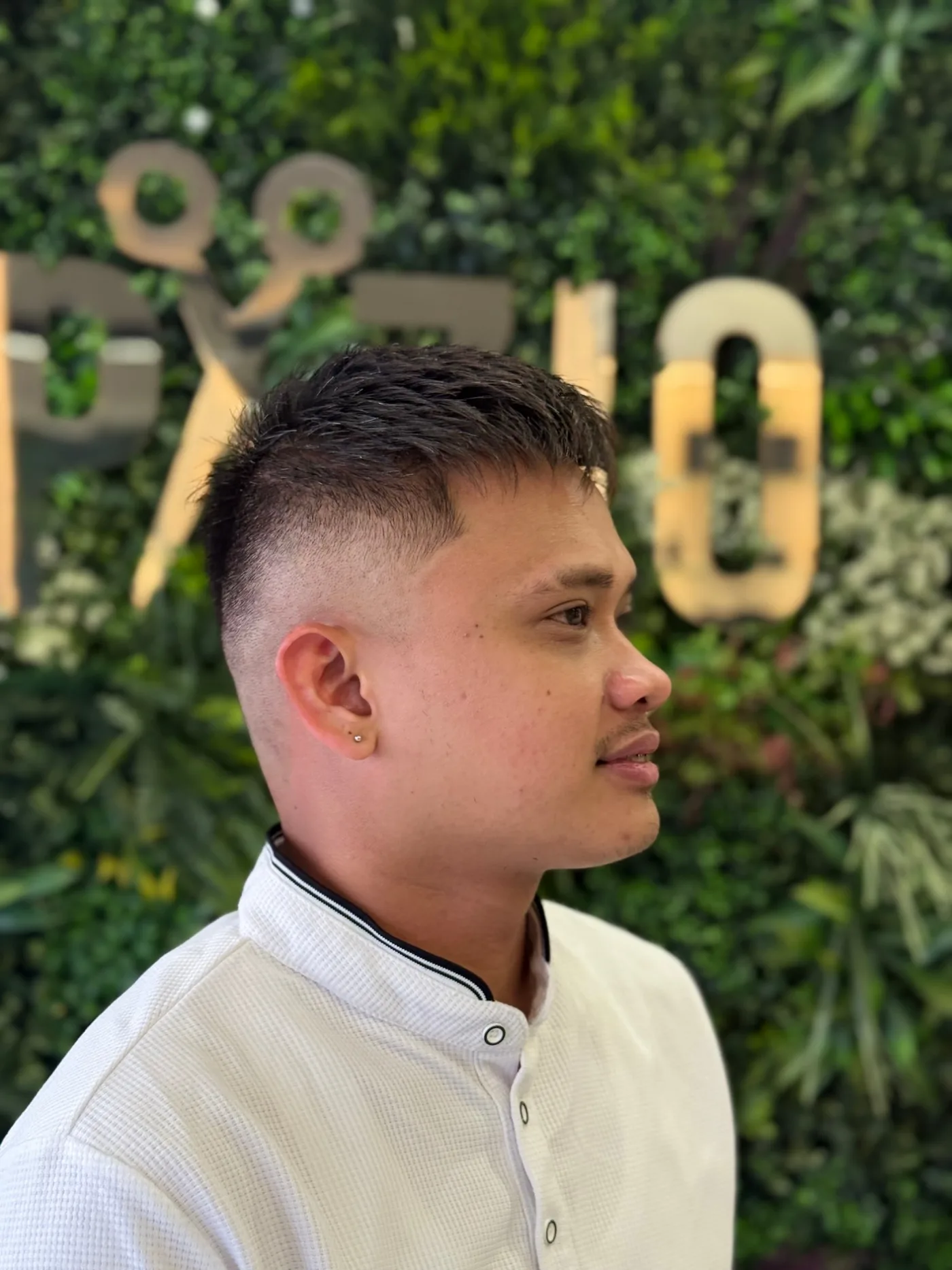 Mid skin fade with a textured crop, finished men’s haircut at the Spazio green wall in Jumeirah Village Circle, Dubai