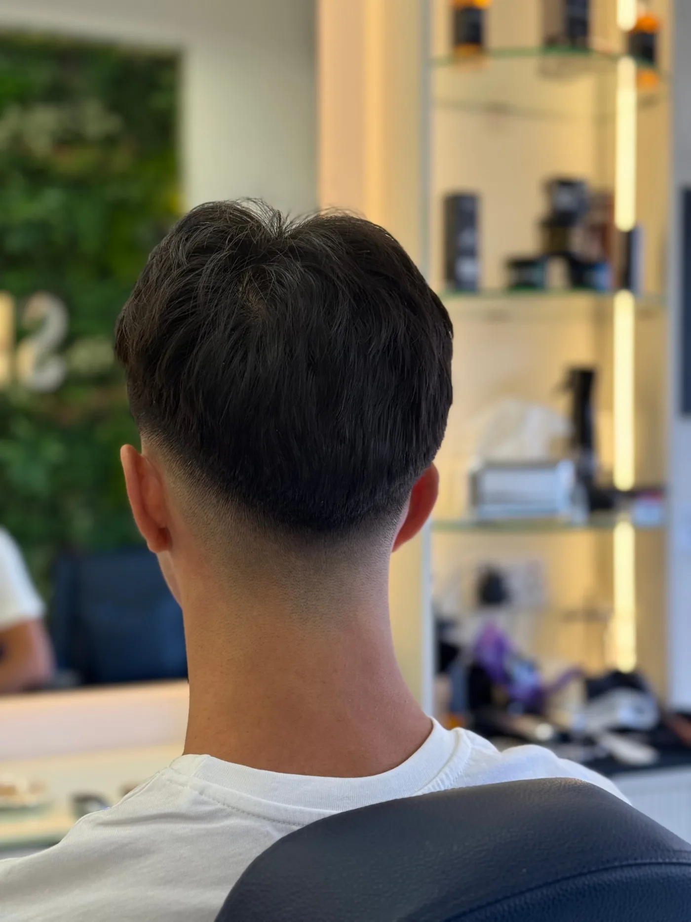 Back view of a taper fade and textured crop, finished men’s haircut at Spazio Gents Salon in Jumeirah Village Circle, Dubai
